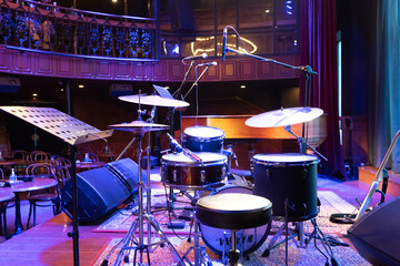 shot showing drum kit with multiple drums cymbals snares bass and more placed on a stage ready for...