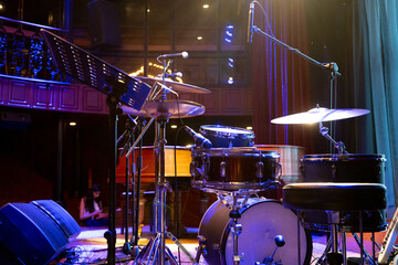 shot showing drum kit with multiple drums cymbals snares bass and more placed on a stage ready for...