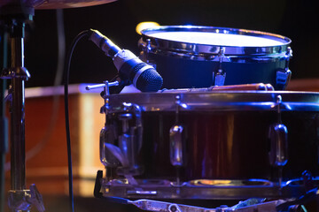 Close up shot showing drum kit with multiple drums cymbals snares bass and more placed on a stage...