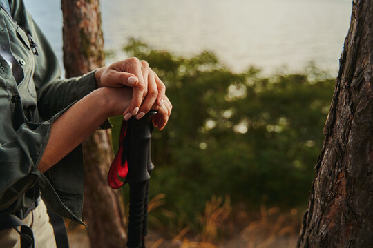 Adult folding her hands on telescoping walking poles