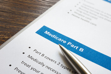 Medicare part B cover list and metal pen. - obrazy, fototapety, plakaty