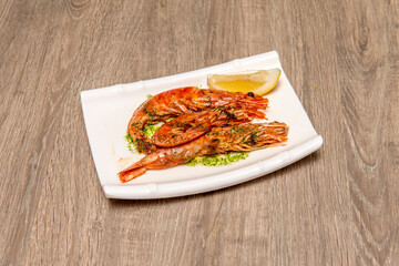 Grilled prawns with typical Andalusian green sauce with a little lemon to garnish.