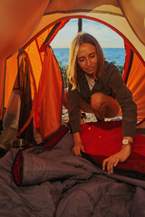 Obraz na płótnie Canvas Tourist preparing a sleeping place inside tent