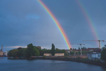 Fototapeta na wymiar Rainbow over a river, rainbow over the Spree River in Berlin, Germany, rainbow over Berlin Schöneweie