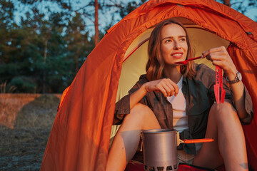 Hiker drinking tea from spoon while camping