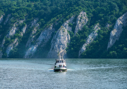 Cruise ship on the Danube. Mountains and vegetation in the background. Romania, Cazanele Dunarii. July, 18, 2021