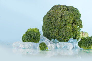 broccoli on a blue background with ice cubes and crushed ice