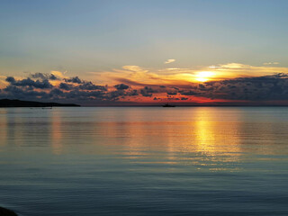 Obraz premium Sunset at the sea. Lovely quiet atmosphere. A ship and fishing nets in the distance
