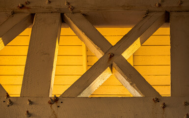 roof support beams and trusses at sunset forming X
