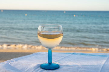 Summer time in Provence, drinking of cold gris rose wine on sandy beach and blue sea near Toulon, Var department, France