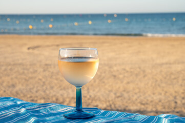 Summer time in Provence, drinking of cold gris rose wine on sandy beach and blue sea near Toulon, Var department, France