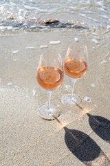 Summer time in Provence, two glasses of cold rose wine on sandy beach near Saint-Tropez, Var department, France