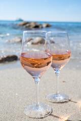Summer time in Provence, two glasses of cold rose wine on sandy beach near Saint-Tropez, Var department, France