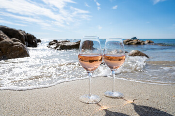 Summer time in Provence, two glasses of cold rose wine on sandy beach near Saint-Tropez, Var department, France