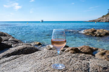 Summer time in Provence, glass of cold rose wine on sandy beach and blue sea near Saint-Tropez, Var department, France