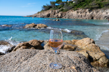 Summer time in Provence, glass of cold rose wine on sandy beach and blue sea near Saint-Tropez, Var department, France