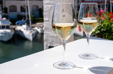 Summer on French Riviera Cote d'Azur, drinking cold dry white wine from Cotes de Provence on outdoor terrase in Port Grimaud, Var, France