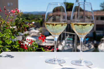 Summer on French Riviera Cote d'Azur, drinking cold dry white wine from Cotes de Provence on outdoor terrase in Port Grimaud, Var, France