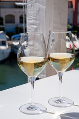 Summer on French Riviera Cote d'Azur, drinking cold dry white wine from Cotes de Provence on outdoor terrase in Port Grimaud, Var, France
