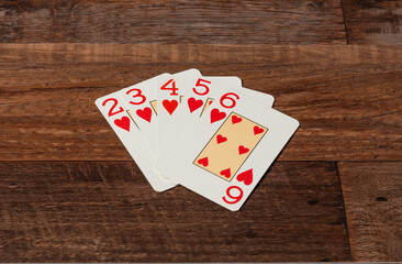 escalera con cartas de poker, sobre una mesa de madera