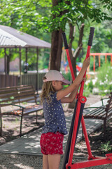 little naughty girl, 6-7 years old on the playground in the summer park