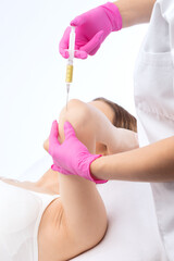Doctor doing stem cell therapy on a patient's elbow after the injury. Treating knee pain with...