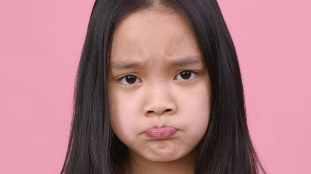 Kid caprices. Close up portrait of asian girl pouting lips, feeling upset and offended, didn't get what she wanted