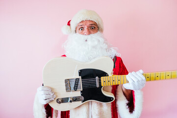 Man dressed as Santa Claus euphoric with electric guitar