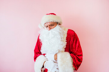 Man dressed as Santa Claus suffering from stomach ache from eating too much