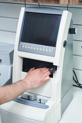 Male optician using optical equipment in workshop