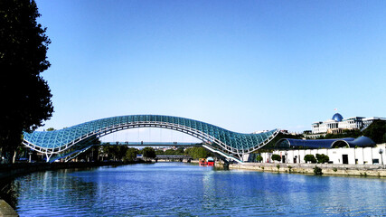 Fototapeta na wymiar Pedestrian bridge over the Kura River in Tbilisi, Georgia