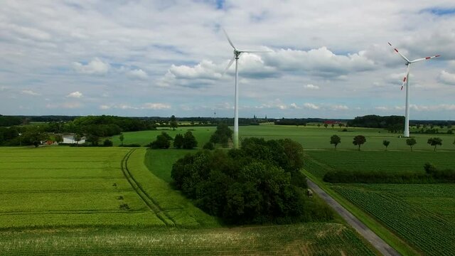 aerial drone view of two windmills on a beautiful cloudy summer day