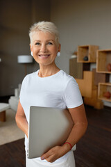 Enthusiastic senior woman ready for new day, in mood to start work. Laptop for remote job from...