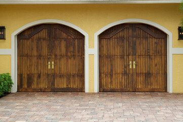 Two sets of wooden garage doors on exterior of building.
