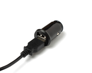 USB wire and black car charger with two USB ports, multifunctional cigarette lighter adapter plug. white background. copy space.