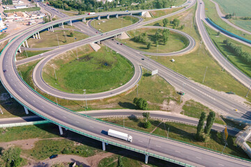 Naklejka premium Motorway with moving cars. Transport interchange. Logistics and delivery of goods. Trucks on the bridge