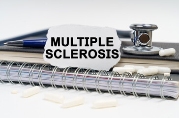 On the table is a stethoscope, a diary and a piece of paper with the inscription - Multiple Sclerosis