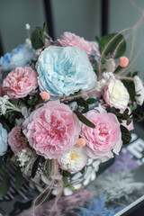 Arrangement of flowers in a round vase. Pink and blue color floral arrangement on white background. Interior decor.