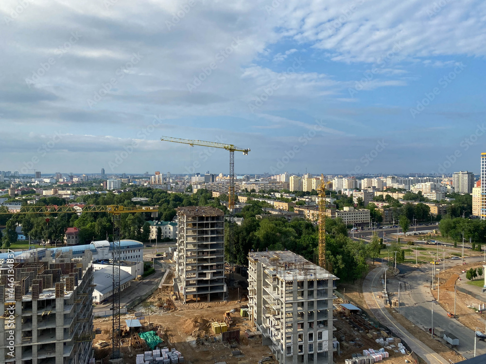 Poster a view from a height of a large modern construction site of tall large houses and multi-storey build