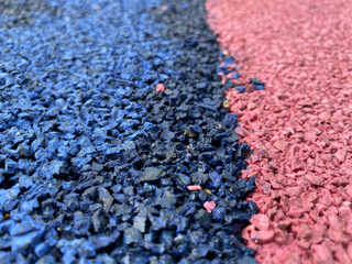Blue and pink rubber surface anti-traumatic safety tile for workout sports playground in public park or courtyard. The background. Texture