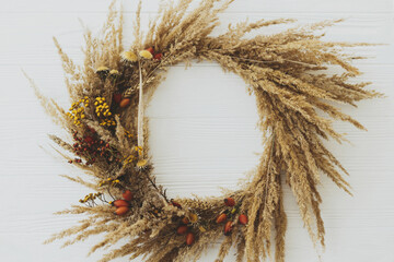 Stylish autumn rustic wreath flat lay. Creative boho wreath with dried pampas grass, tansy...