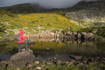 person in front of a small lake contemplating the landscape