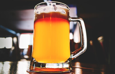 glass of light beer stands on a table in a bar or pub