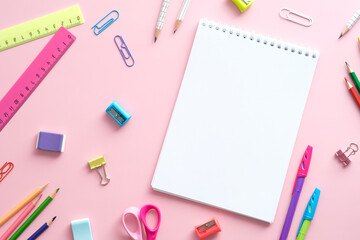 Flat lay school supplies and paper notebook on pink background. Back to school concept.