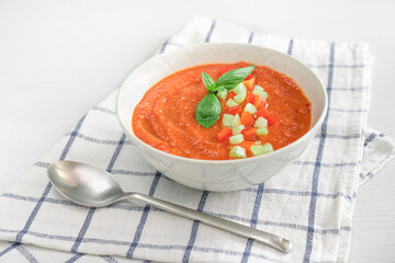 Plate of Spanish tomato soup Gazpacho on white wood table 