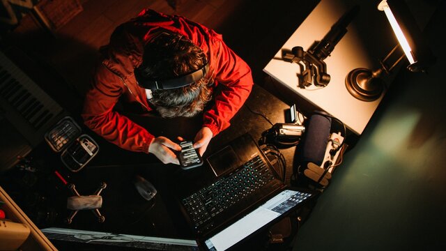 Man Content Creator Hard at work at His Desk Late into the Night