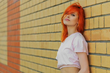 Beautiful young woman near a wall