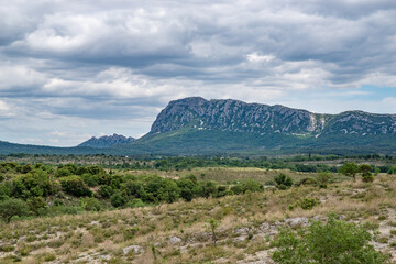 Ravin des Arcs hiking landscape, in the south of France. Pic Saint Loup with cloudy summer sky