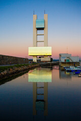 Maritime watchtower of A Coruna reflected in the water at sunset