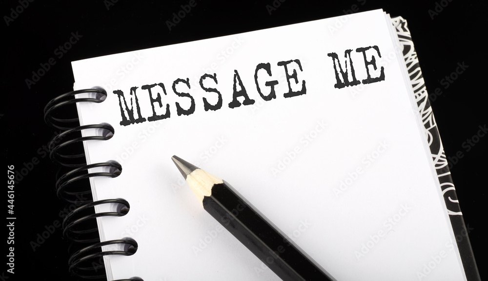 Poster message me written text in small notebook on a black background